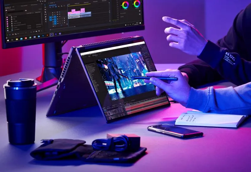 Creator editing video on laptop in a vibrant neon-lit workspace